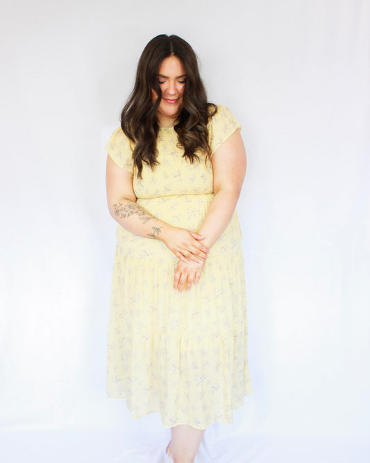 Pastel yellow smocked floral midi dress with flutter sleeves and tiered skirt