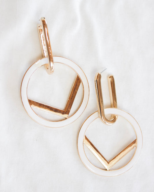 Big statement earring with oval into detached white circle outlined gold with gold V detail in the middle
