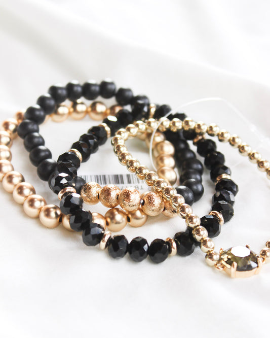 Four black and gold mix assorted stackable bracelets 