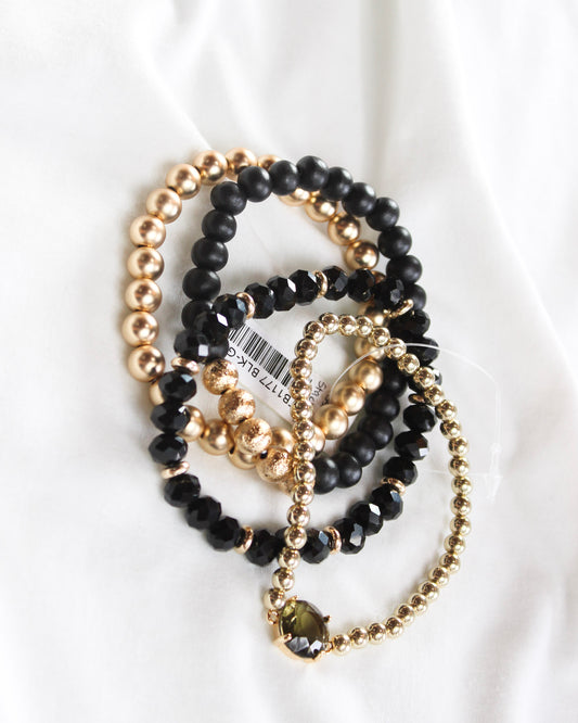 Four black and gold mix assorted stackable bracelets 