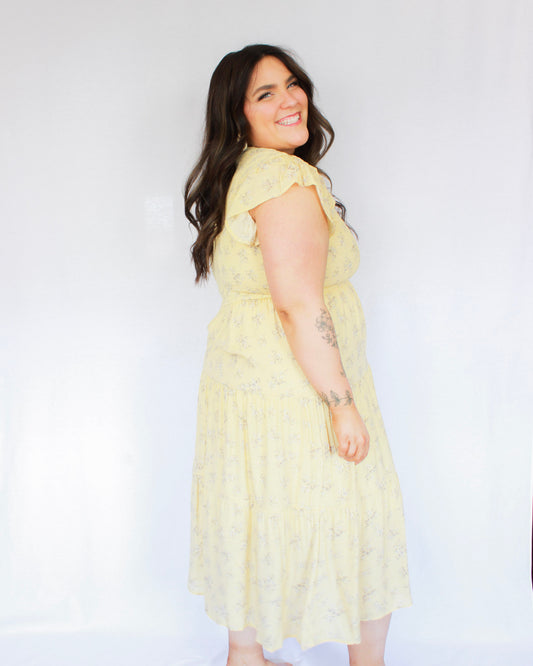 Pastel yellow smocked floral midi dress with flutter sleeves and tiered skirt