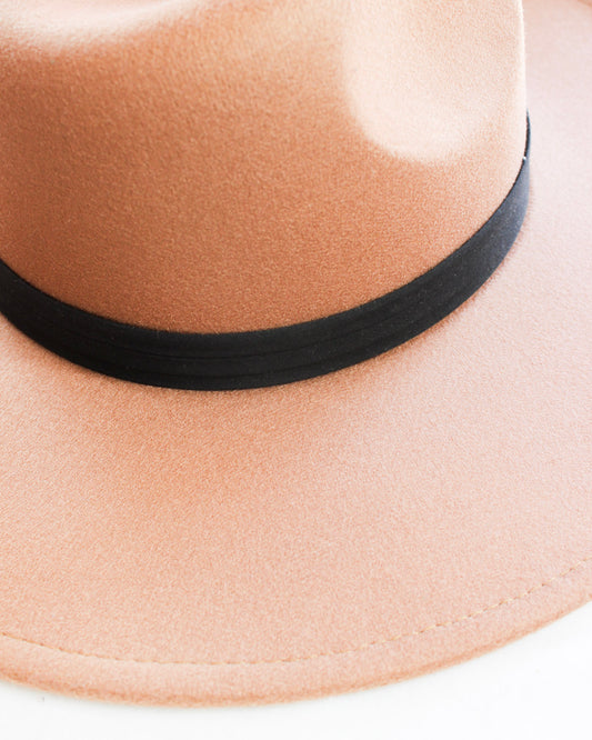 Tan Wide brim fedora hat with black ribbon around the base 