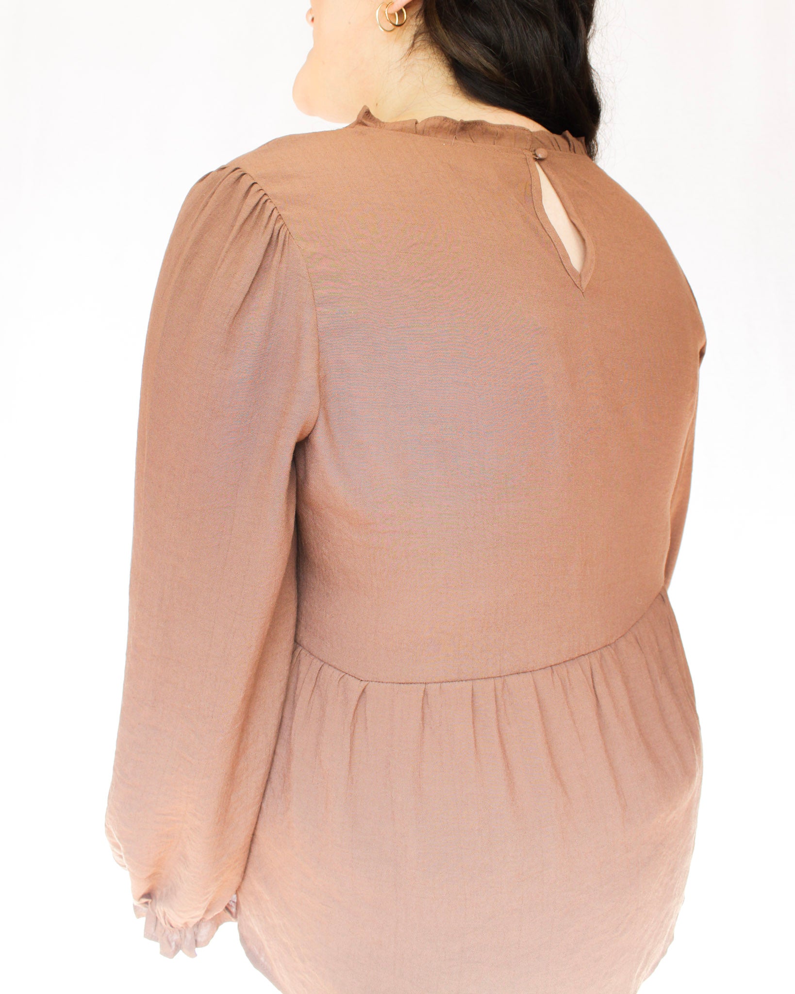 Brown long sleeve peplum long sleeve top with white floral detailing down the front sides