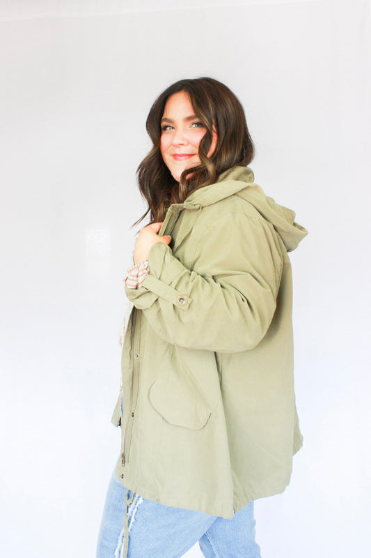 Army green zip up and button closure jacket with hoodie, two pockets, tieing strings for hood and bottom hem long length 