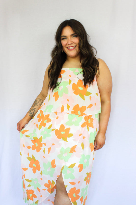 White high low dress with big floral design in bright orange, green, and pale pink adjustable spaghetti strips high round neckline
