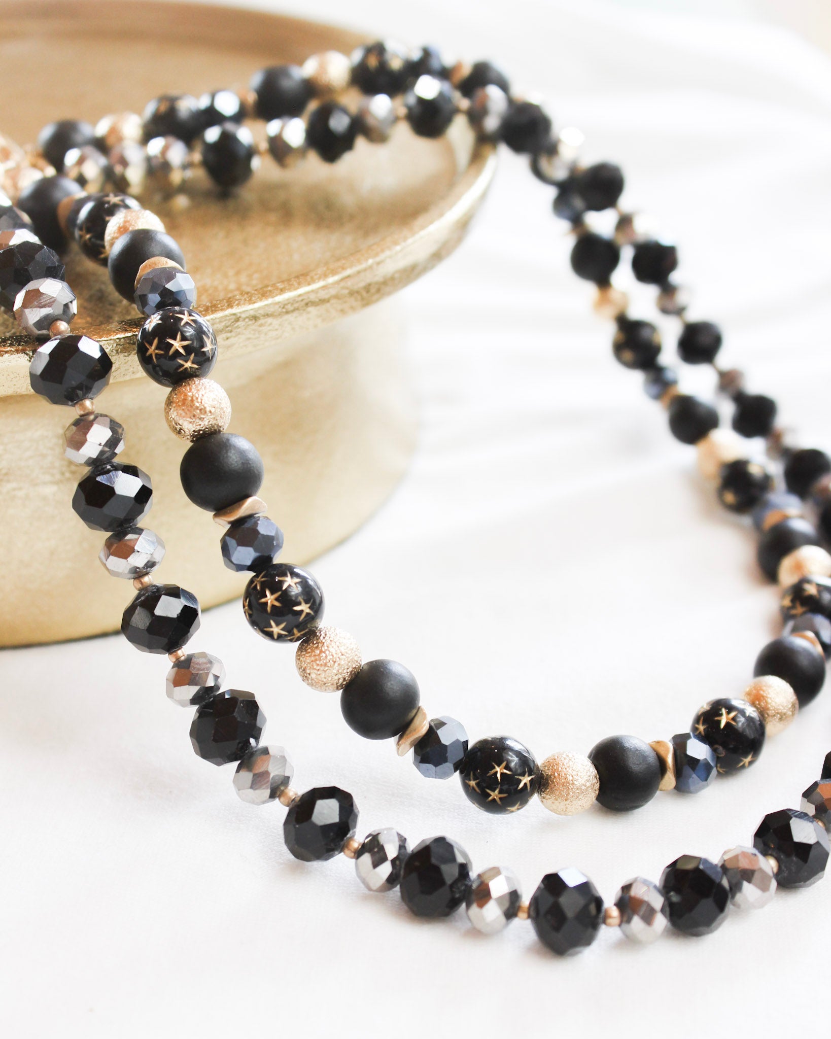 Black assorted layered bead necklace with gold details and mini stars 