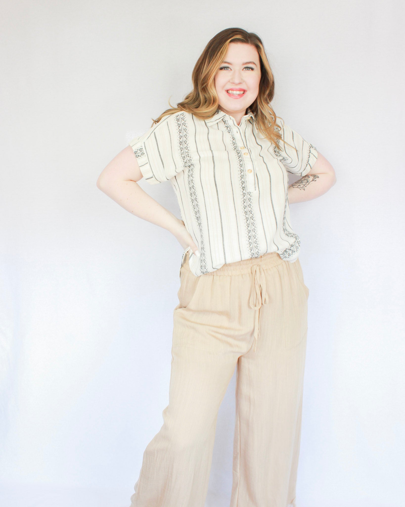 Tan flowy thin pants with built in shorts, drawstring waistband, two pockets, and frayed bottoms