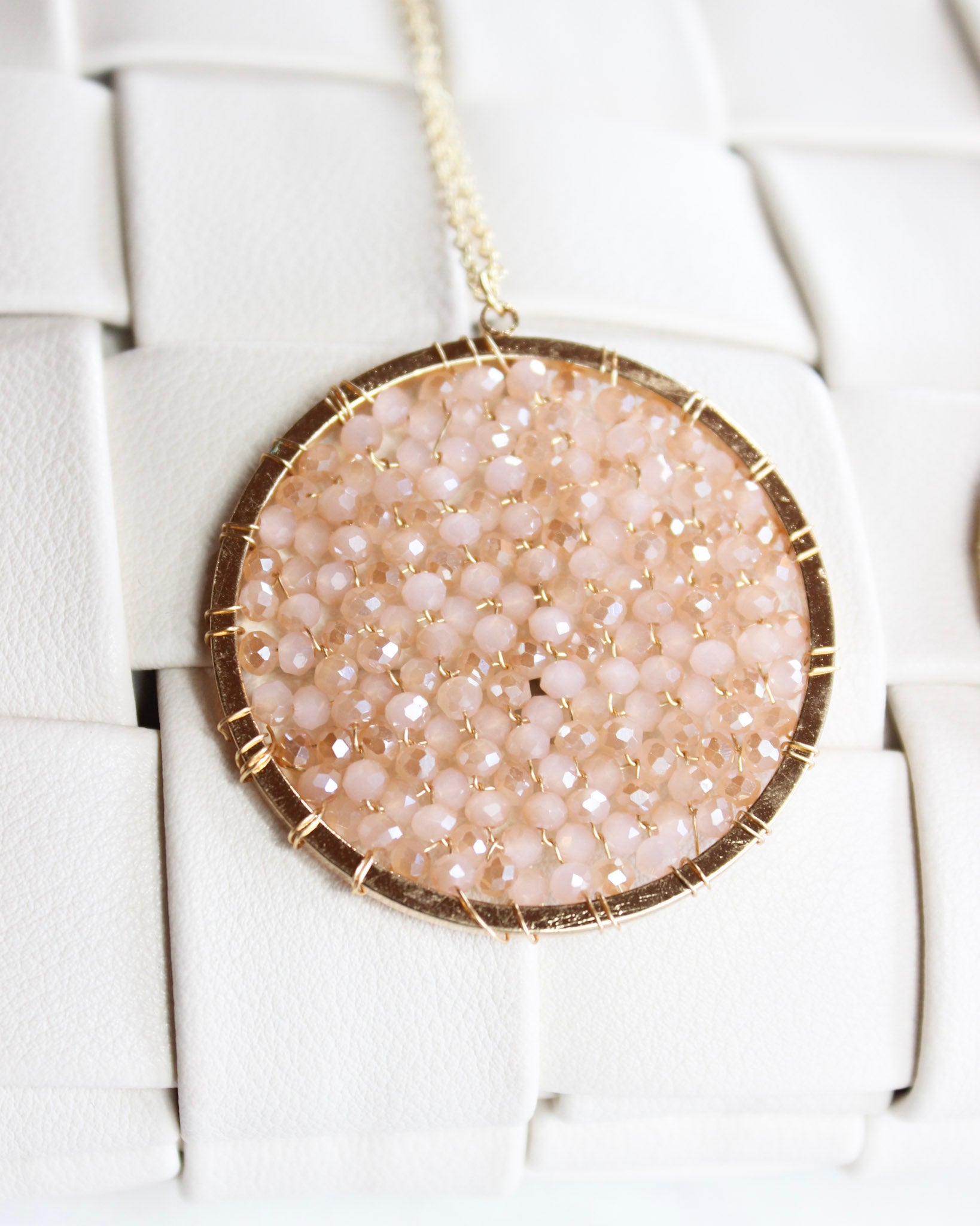 long gold chain necklace with a round pink crystalized filled circle pendant