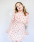 White mini floral dress with bright pink flowers, puff short sleeves, and high neckline 