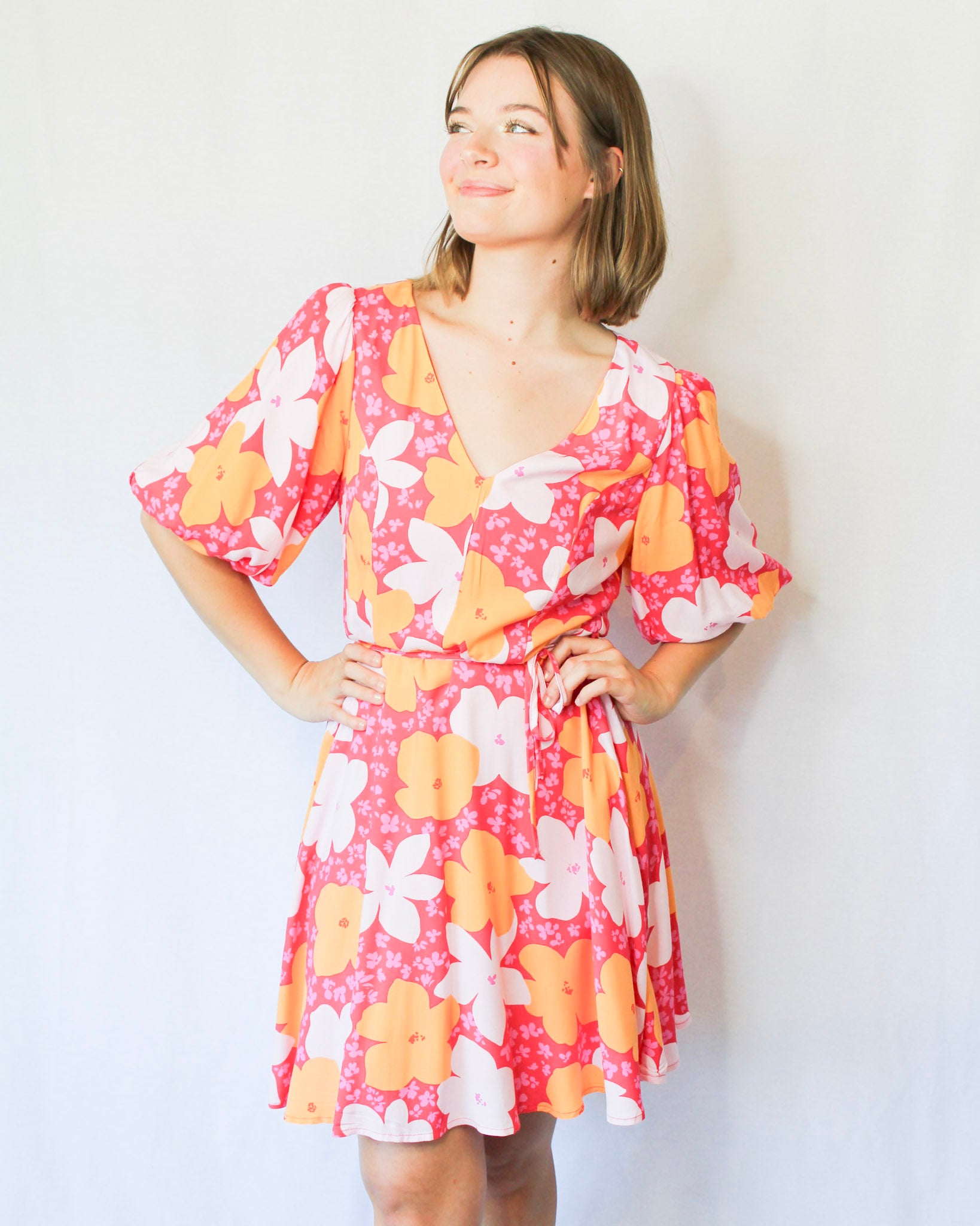 Bright hot pink mini dress with big white, orange, mini pink flowers V neckline flowy skirt puff sleeves and waist tie