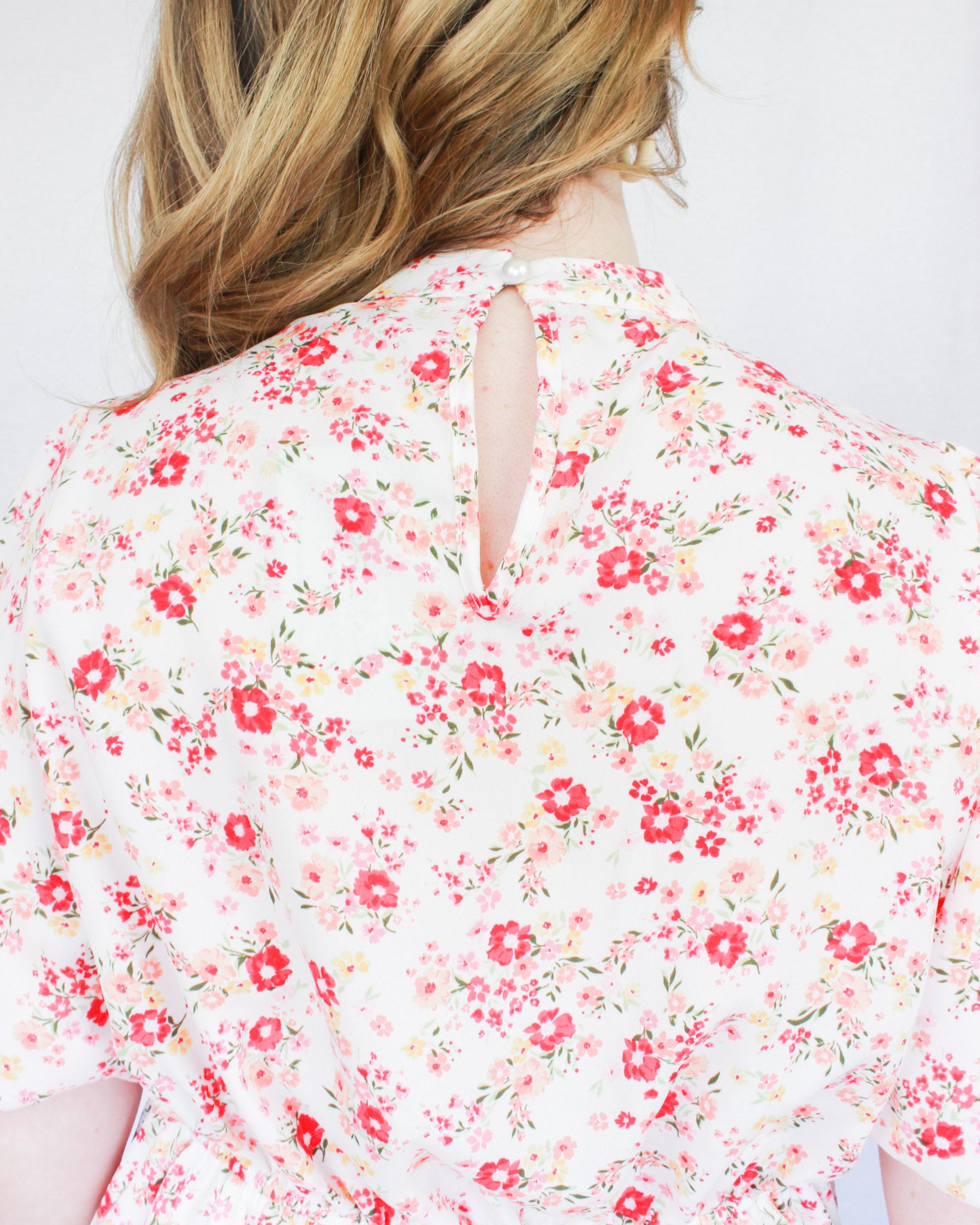 White mini floral dress with bright pink flowers, puff short sleeves, and high neckline 