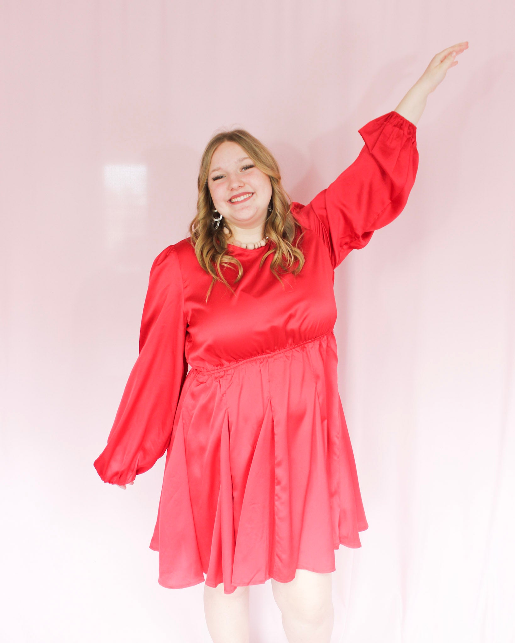 Shiny silk red mini dress with balloon sleeves, skirt with movement, high neckline and open back with tie closure on top