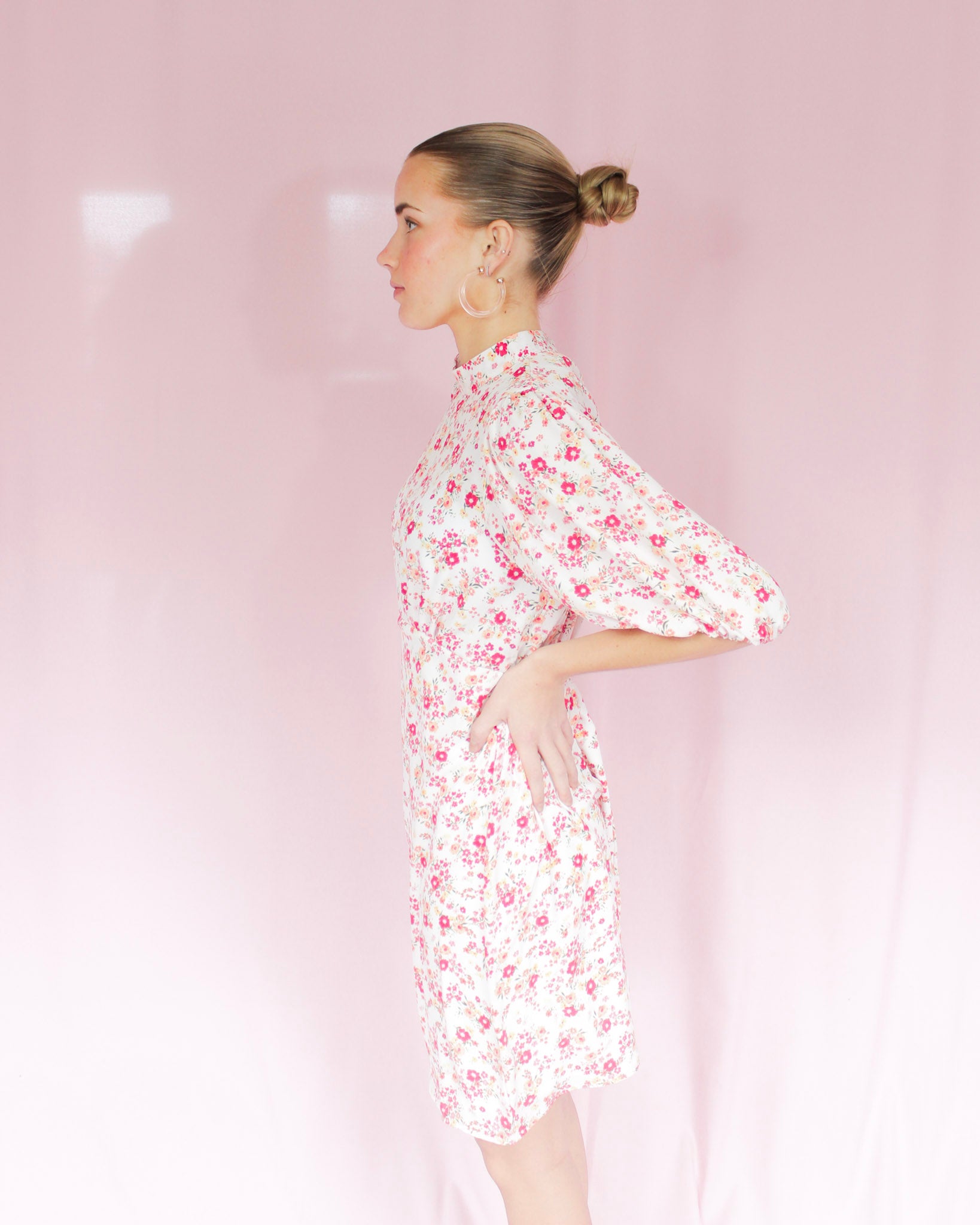 White mini floral dress with bright pink flowers, puff short sleeves, and high neckline 