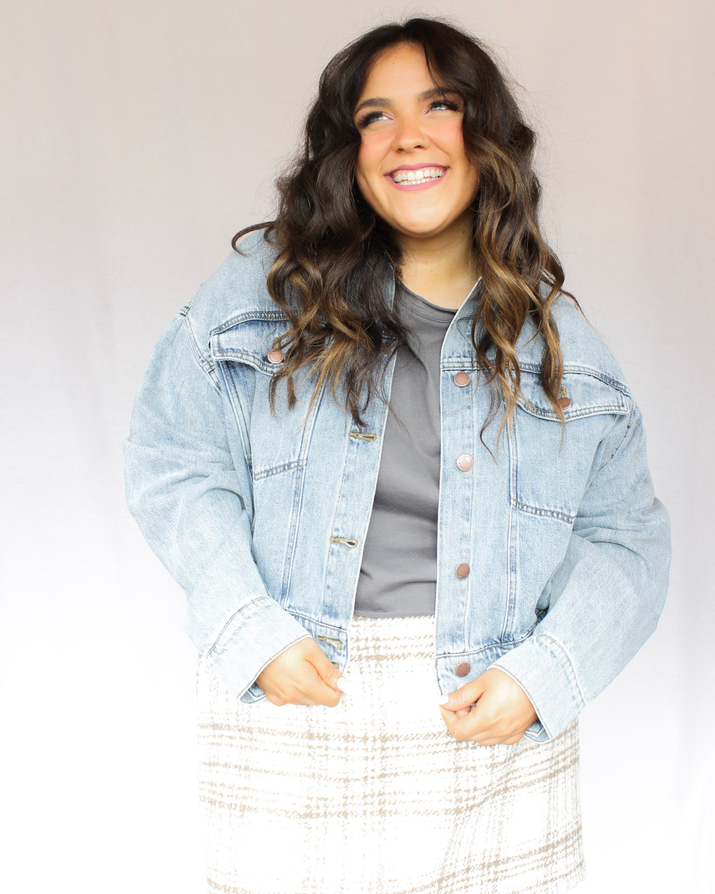 Slightly cropped light wash stretchy denim jacket with two chest pockets and two hand pockets, silver buttons