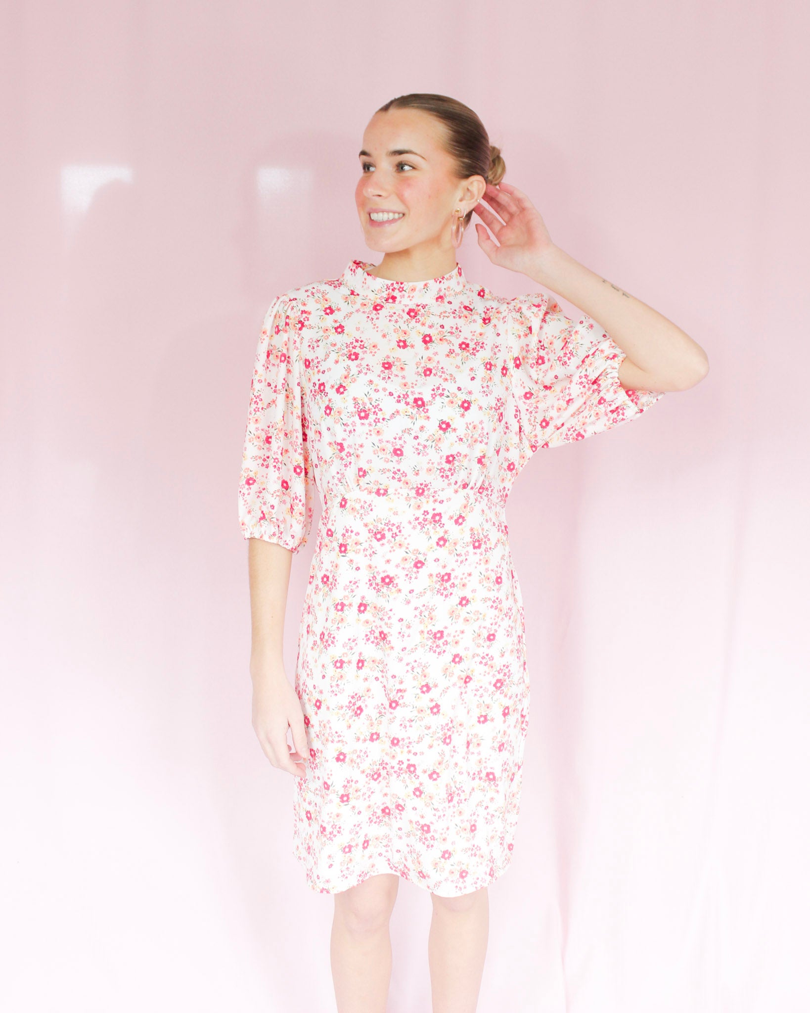 White mini floral dress with bright pink flowers, puff short sleeves, and high neckline 