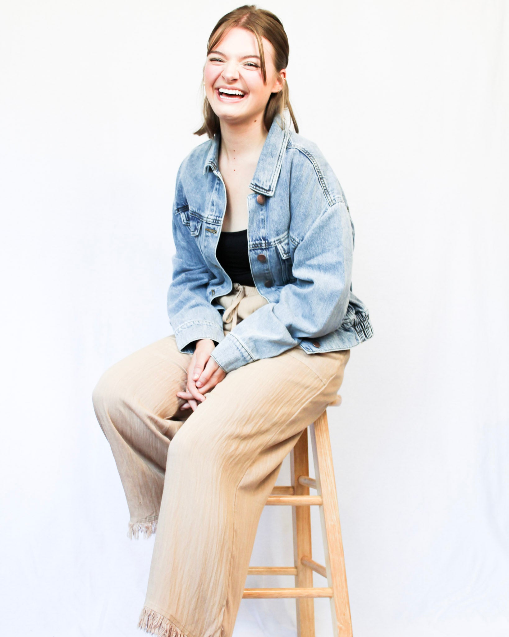 Slightly cropped light wash stretchy denim jacket with two chest pockets and two hand pockets, silver buttons