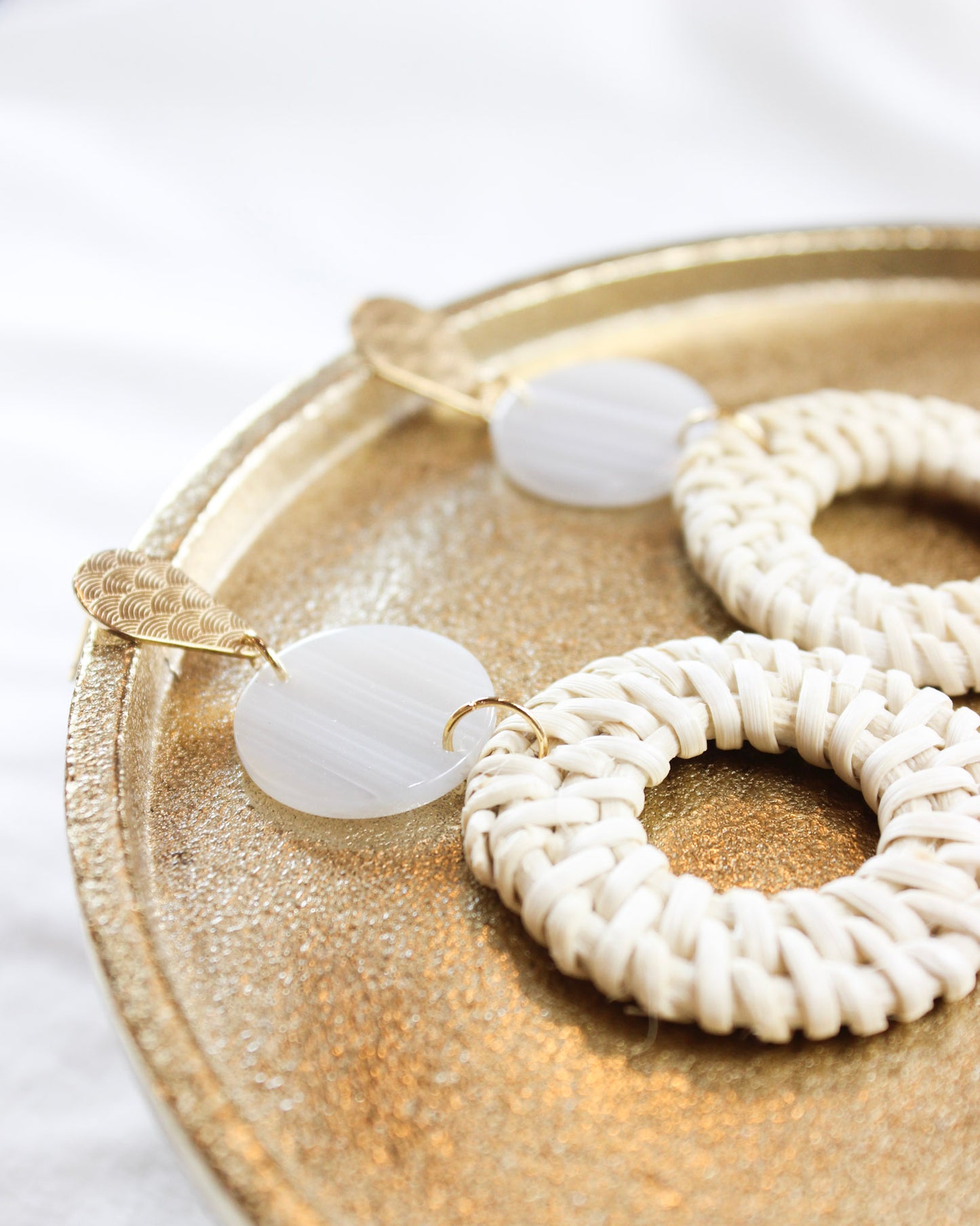 boho style statement earrings with gold accents and tortoise circle into a big wicker round circle 