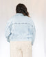 Slightly cropped light wash stretchy denim jacket with two chest pockets and two hand pockets, silver buttons