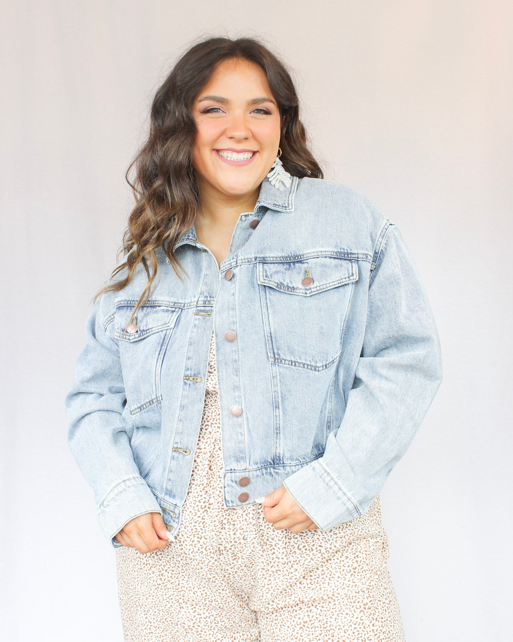 Slightly cropped light wash stretchy denim jacket with two chest pockets and two hand pockets, silver buttons